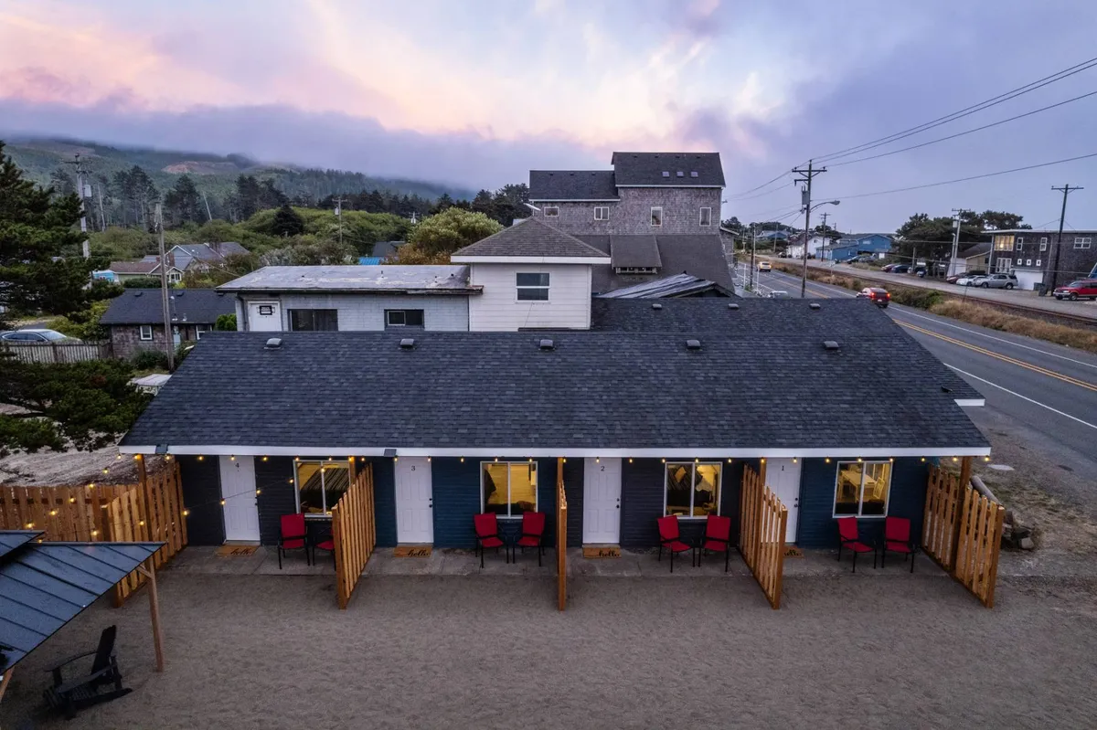 The cottage's inviting facade with outdoor seating nestled in landscaped surroundings. Guests are seen enjoying sunset views, chatting, and relaxing—a perfect complement to the narrative of community and outdoor enjoyment.